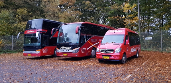 Røde turistbusser parkeret på efterårsvej